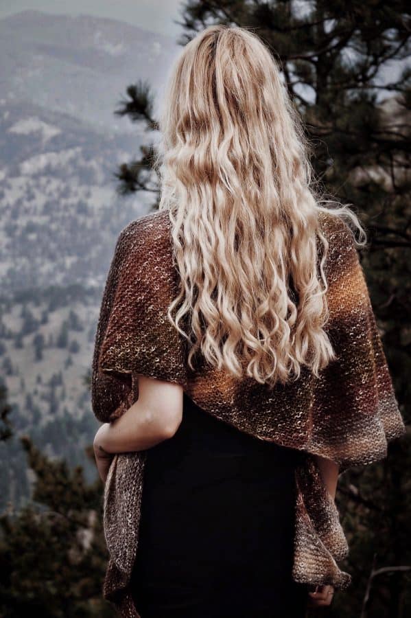 Knitted triangle shawl scarf in textured stitch pattern draped over shoulders - Canyon Scarf pattern by Darling Jadore