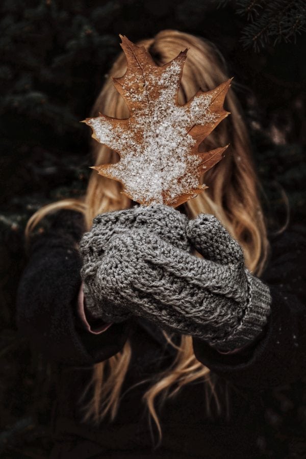 Crochet mittens with cable texture in cream yarn laid flat - Driftwood Mittens pattern by Darling Jadore