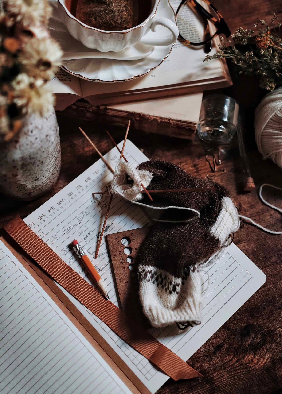 Hand-knitted socks in neutral yarn displayed on wooden surface - sock knitting patterns by Darling Jadore