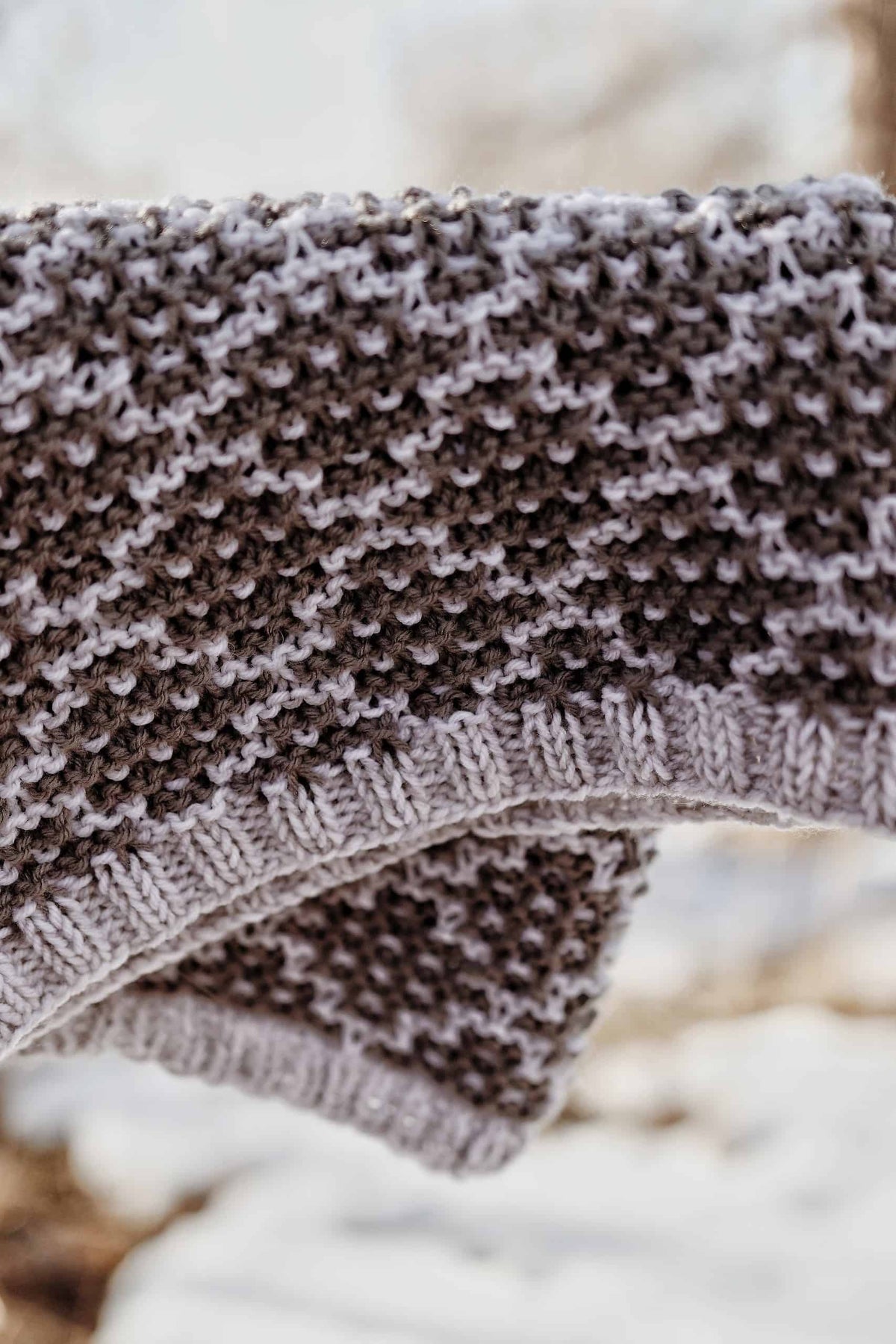 Beige mosaic knit cowl with textured diamond pattern draped elegantly around neck