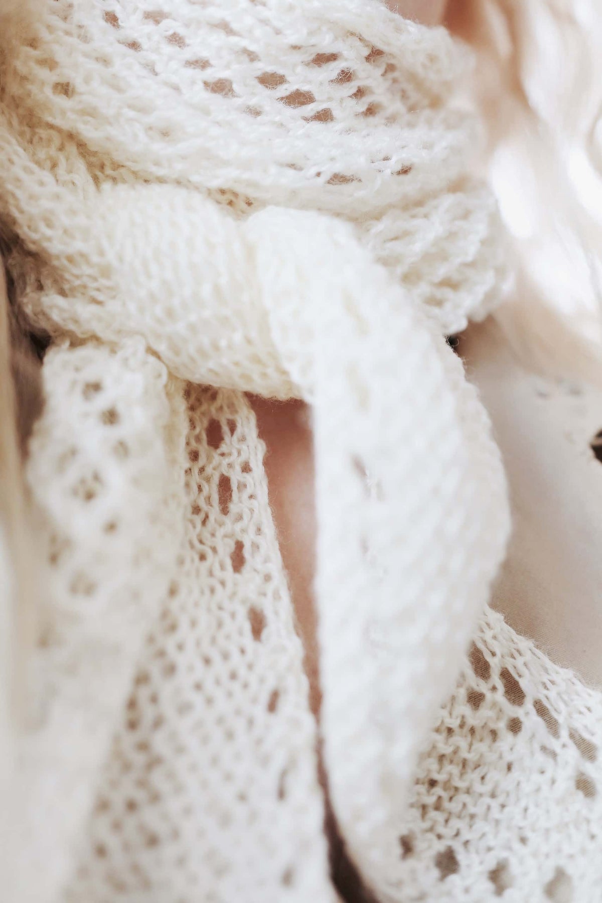 Cream knitted scarf with textured stitch pattern draped elegantly - Solstice Scarf knitting pattern by Darling Jadore
