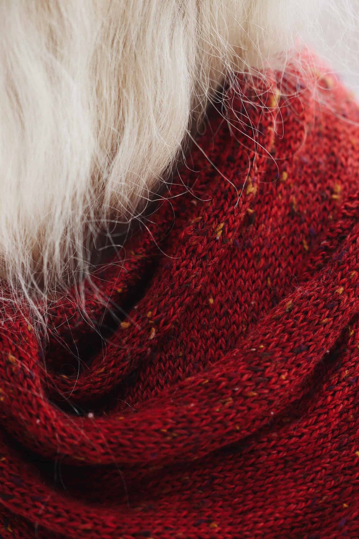 Red knitted scarf draped elegantly showing textured stitch pattern - beginner-friendly scarf knitting pattern by Darling Jado