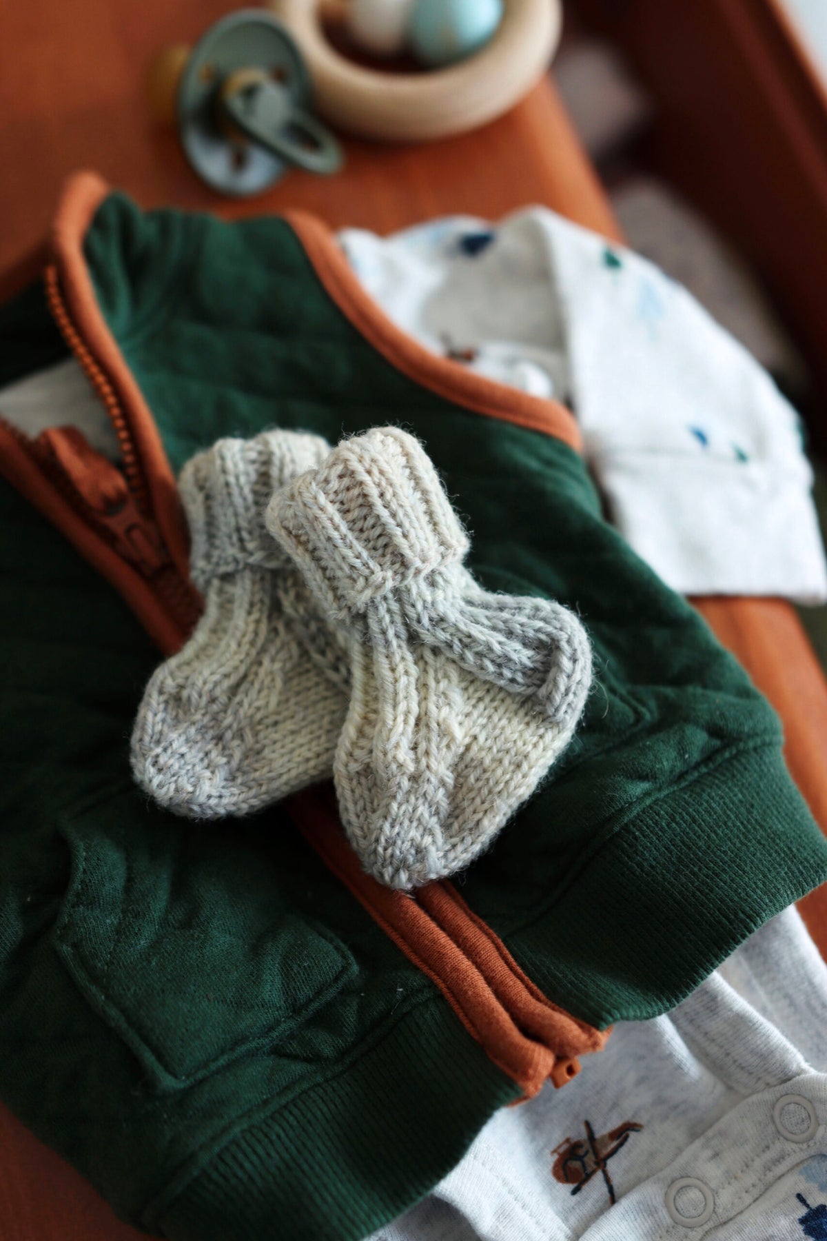 Knitted baby booties in soft cream yarn with ribbed cuffs - beginner-friendly newborn socks knitting pattern by Darling Jador
