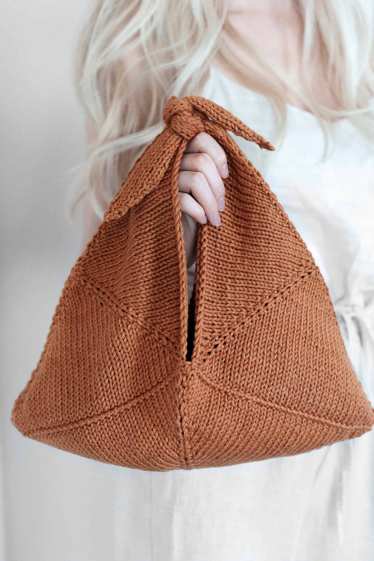 Knitted bento bag in cream yarn with wooden handles and textured stitch pattern - tote purse knitting pattern by Darling Jado