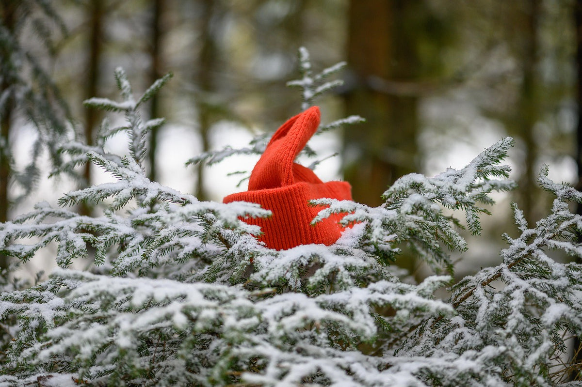 Hand-knitted wool item being washed in fresh snow demonstrating traditional snow washing technique for knits