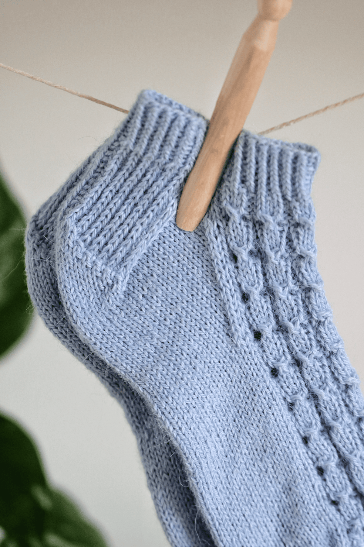 Hand knit blue shortie socks with lace swirl pattern and sturdy heel construction