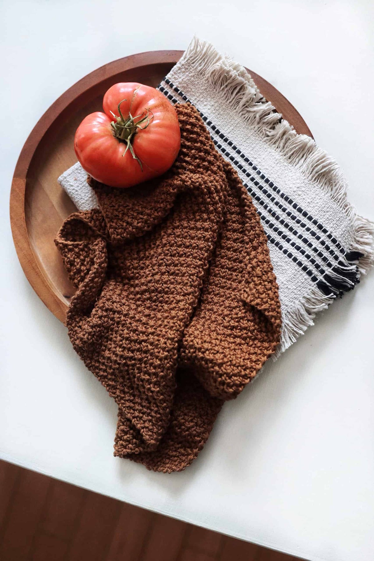 Cream knitted tea towel with textured stitch pattern hanging on wooden rod - Kobuk Tea Towel pattern by Darling Jadore