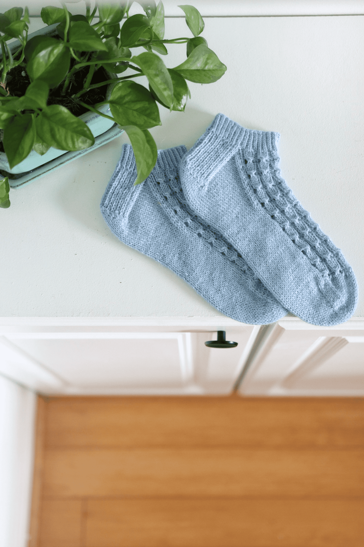 Close-up of Cornflower socks lace knitting pattern showing eyelet and twist details