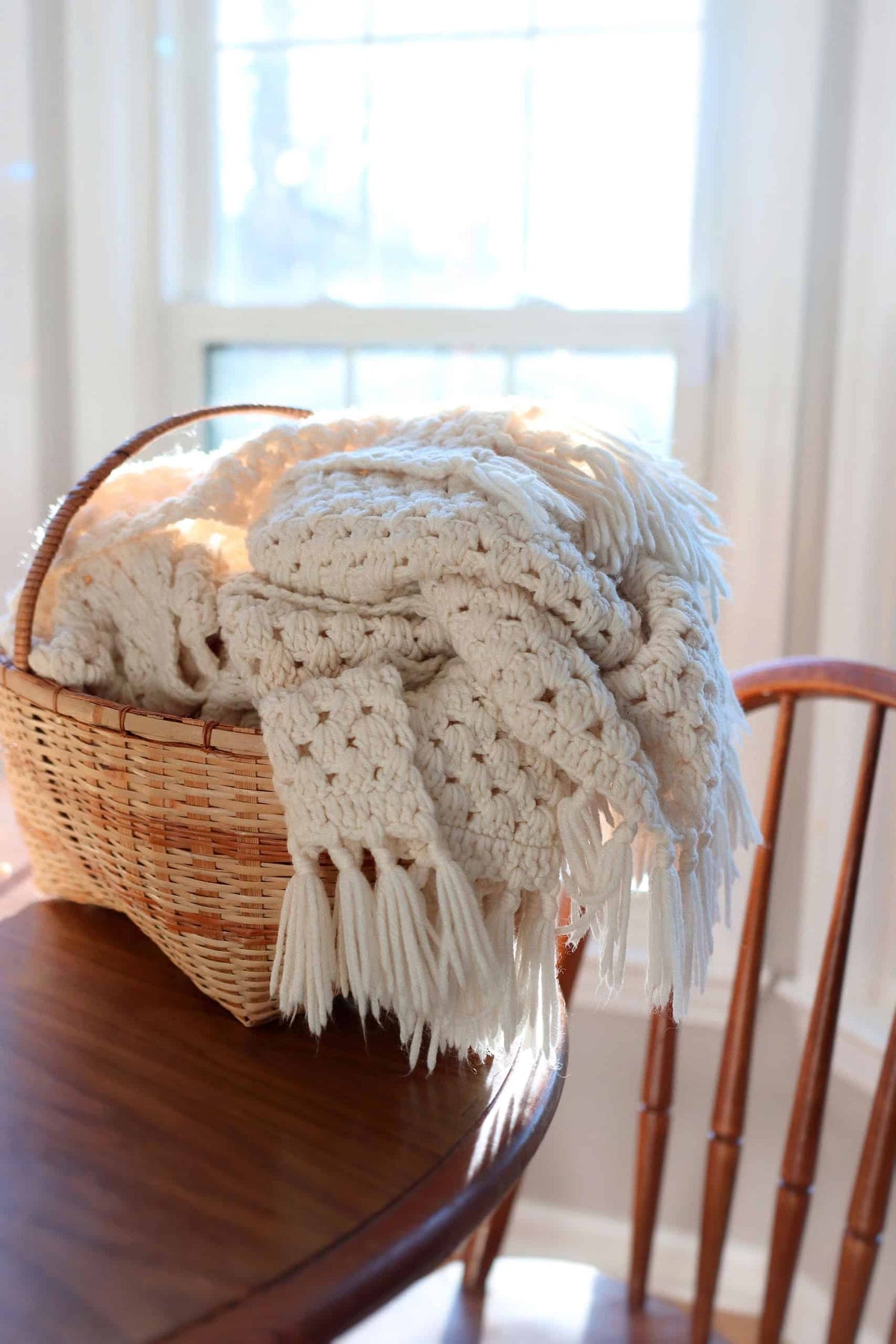 Brookhaven Throw crochet pattern - classic granny square blanket with tassels draped over chair