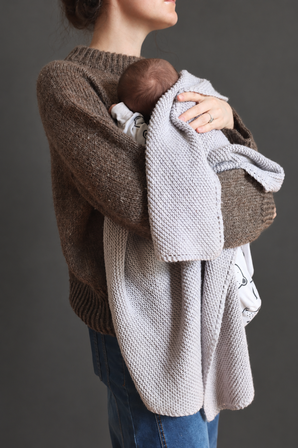 Grey knit baby blanket wrapped around a baby - The Classic Baby Blanket Knitting Pattern by Darling Jadore