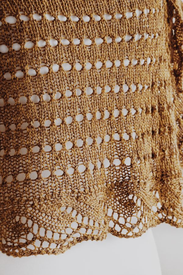 Half circle lace shawl laid flat displaying crescent shape and wave border pattern