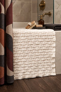Modern woven bath mat crochet pattern in neutral bathroom setting with natural light