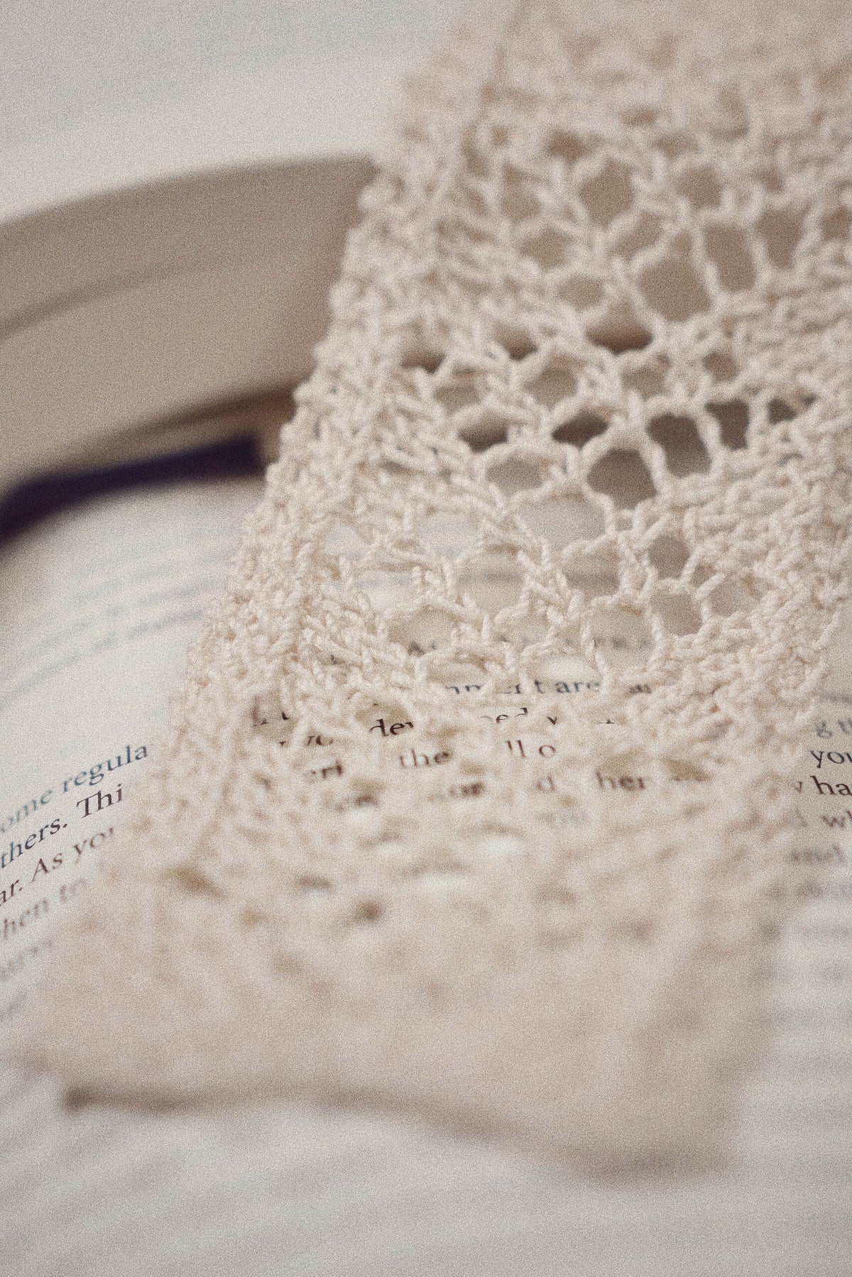 Handmade lace bookmark knitting pattern draped elegantly over book pages