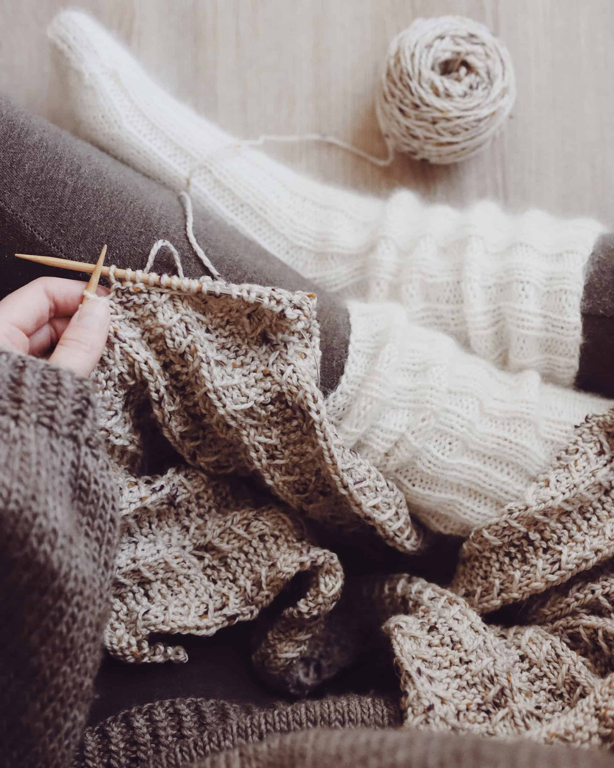 Cozy cream socks knitting pattern flat lay with soft yarn and needles