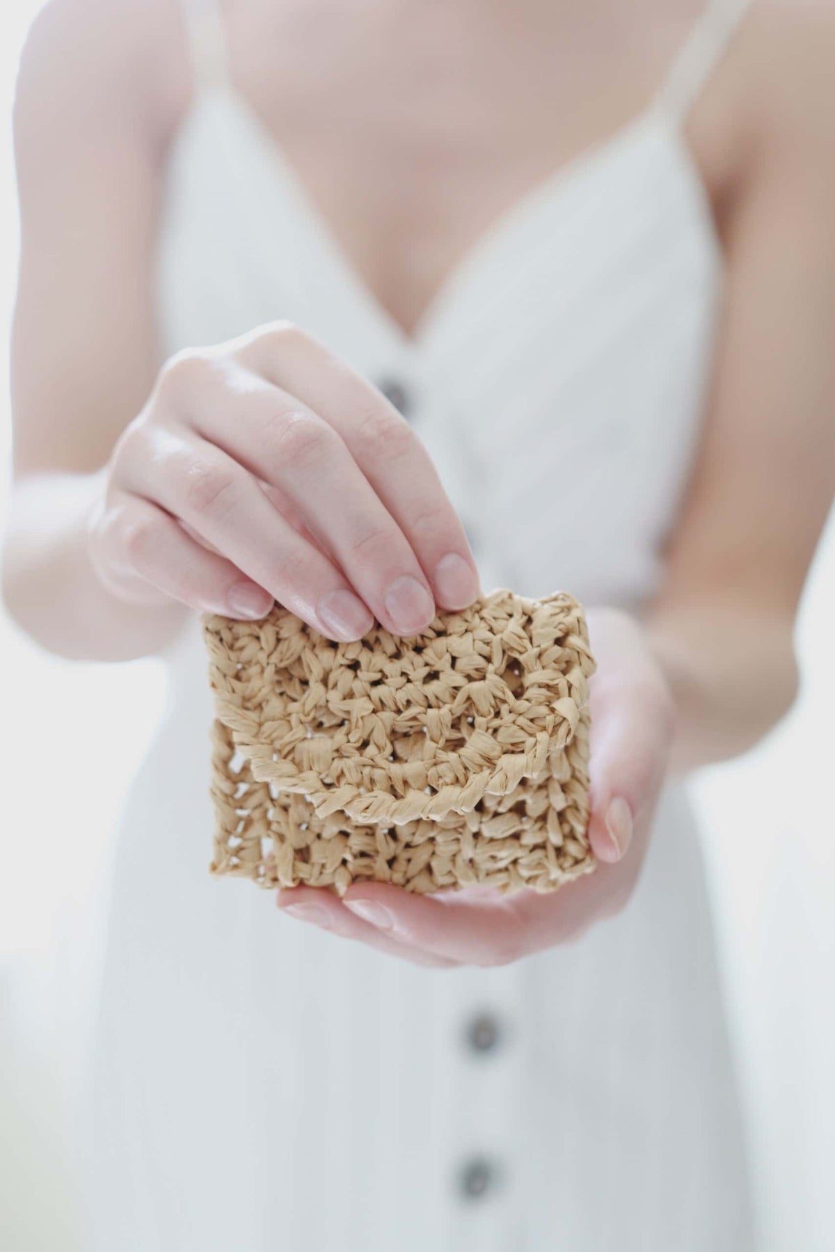 Close-up of crochet raffia coin purse showing classic stitch texture and button fastener