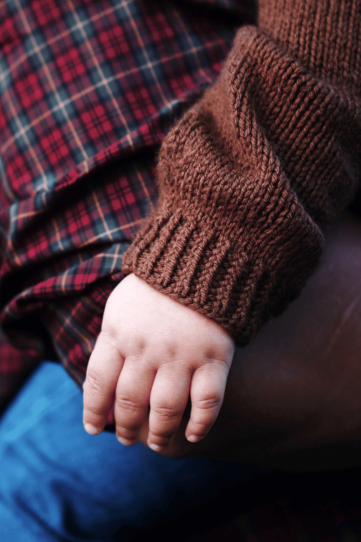 Close up of baby sweater knitting pattern showing cozy raglan sleeve construction
