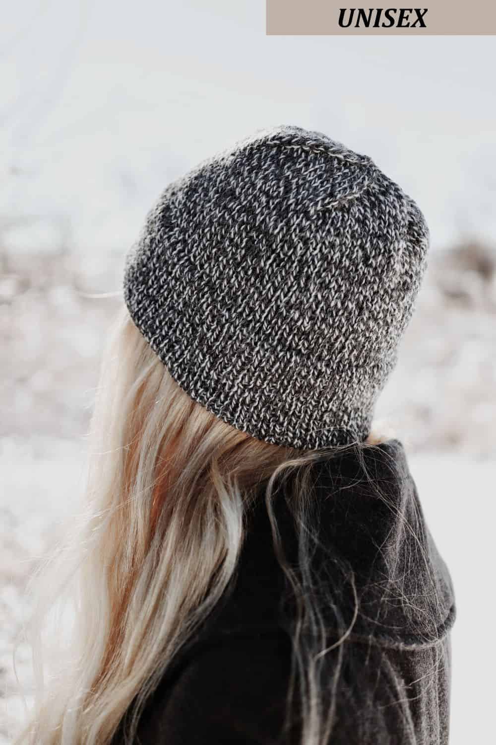 Woman wearing gray cabin beanie knitting pattern in cozy winter setting