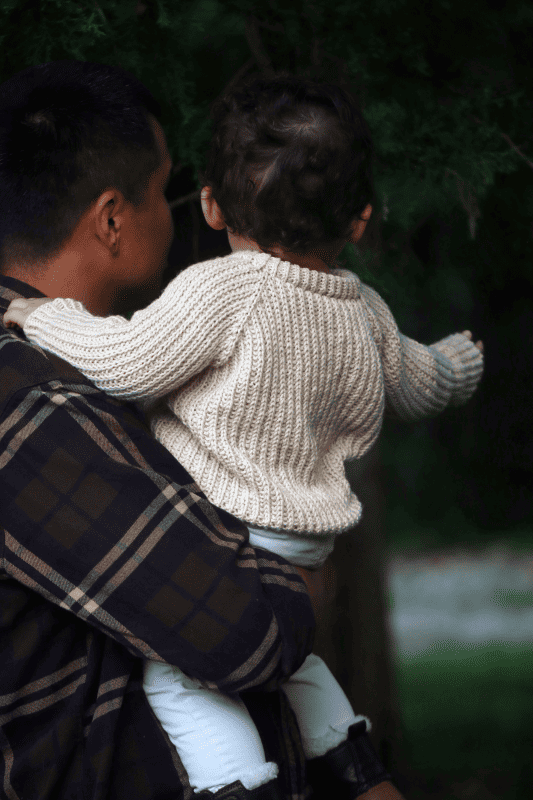 Newborn pullover knitting pattern showing raglan sleeve detail and ribbed hem