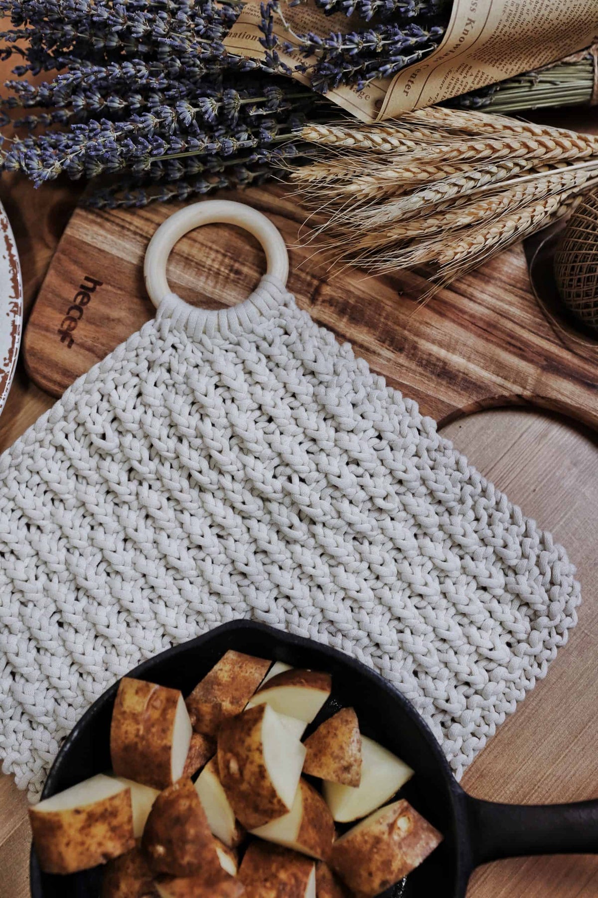 Hand-knit trivet with wooden ring displayed on kitchen counter