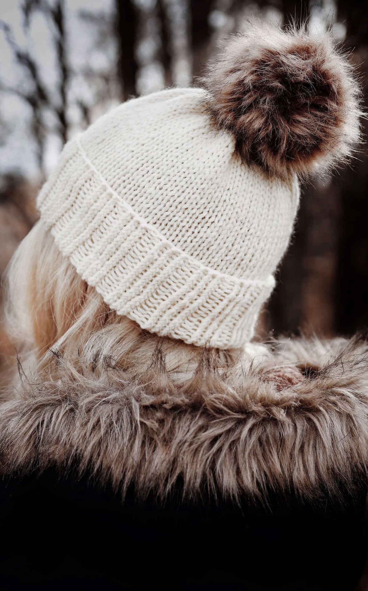 Side view of handknit Phlox beanie pattern featuring flower-inspired lace design on cream colored yarn