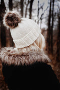 Classic beanie knitting pattern in cream yarn with ribbed brim and textured stitches