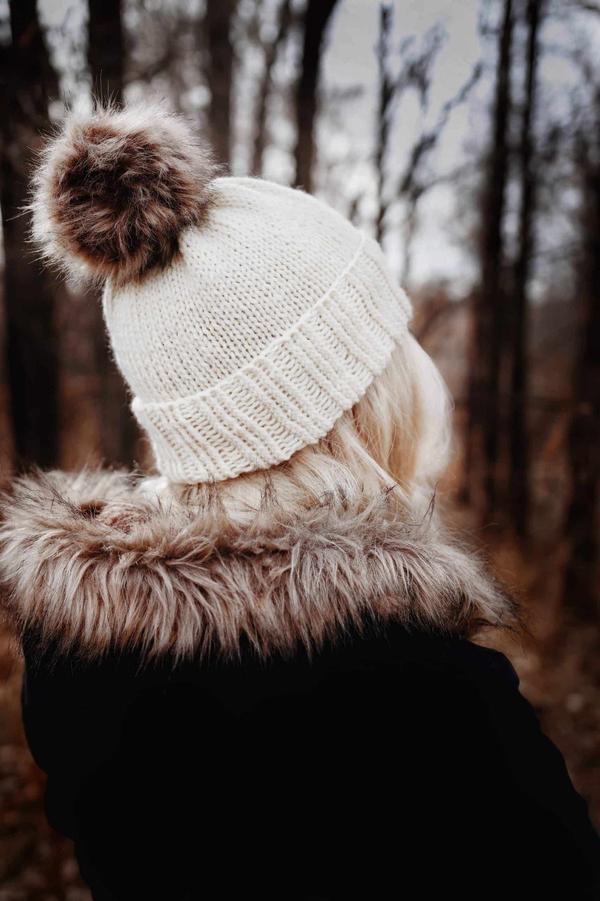 Classic beanie knitting pattern in cream yarn with ribbed brim and textured stitches