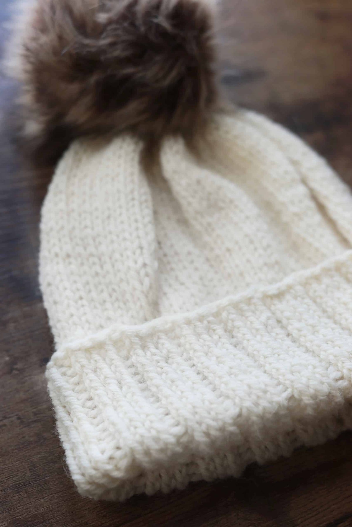 Classic toque knitting pattern in neutral yarn showing beautiful stitch definition