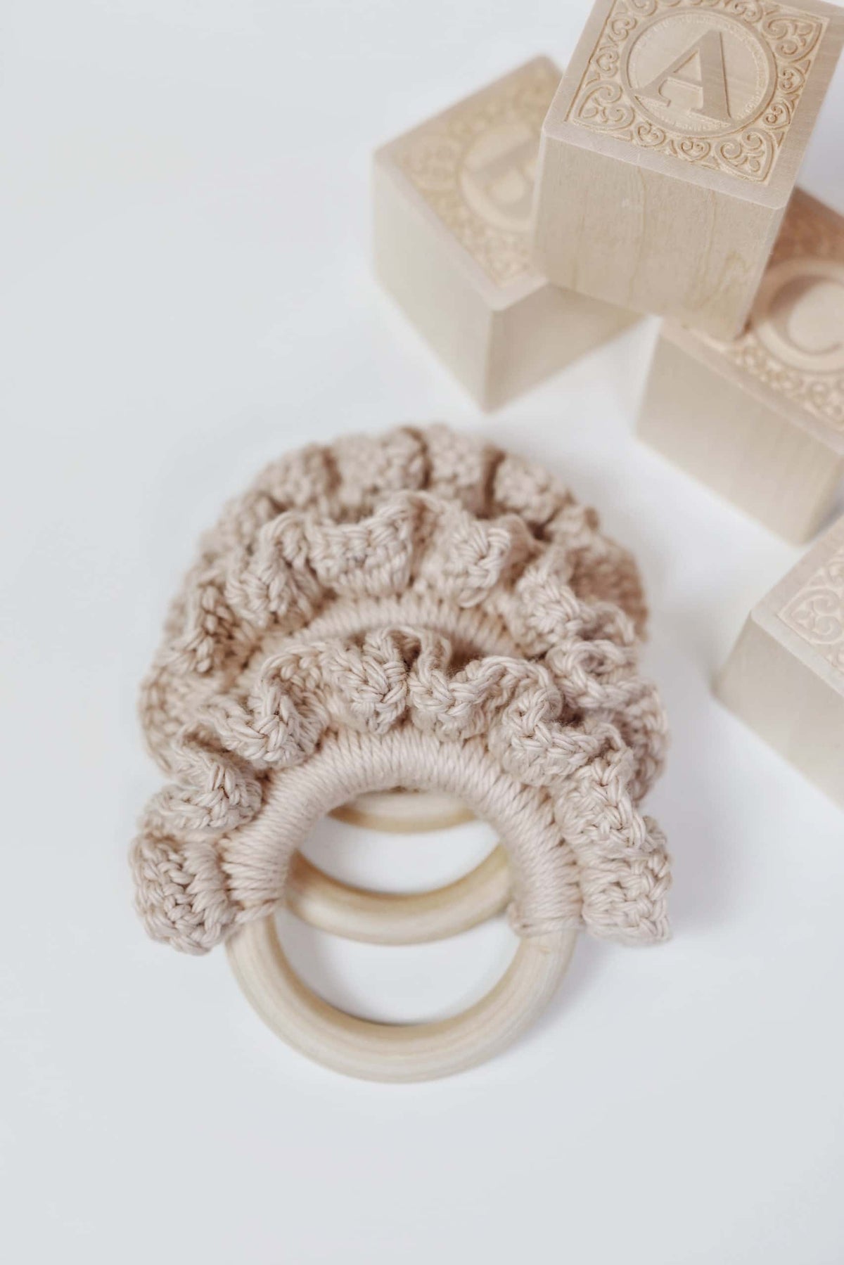 Baby teether crochet pattern with wooden ring and soft cotton waves for safe play