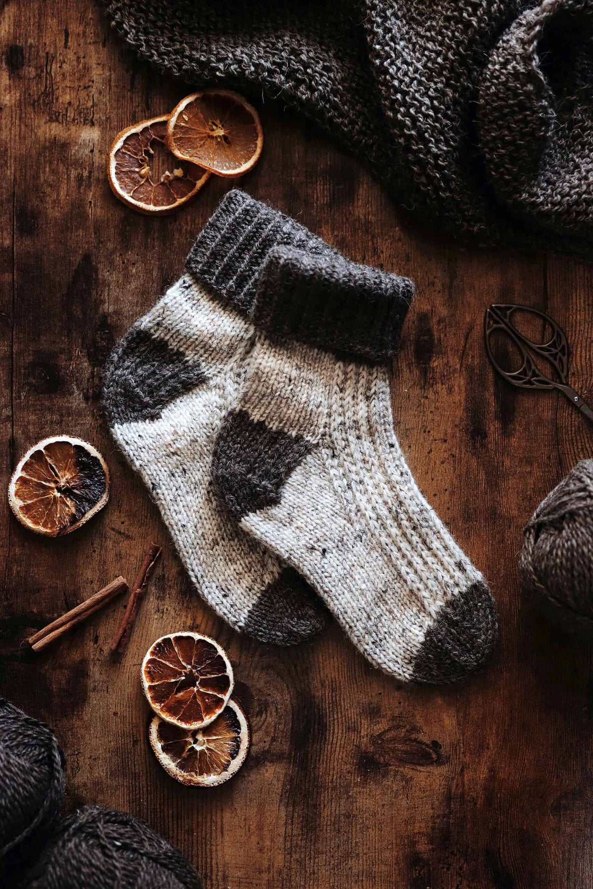Cozy winter socks knit in cream worsted yarn styled with rustic wooden background