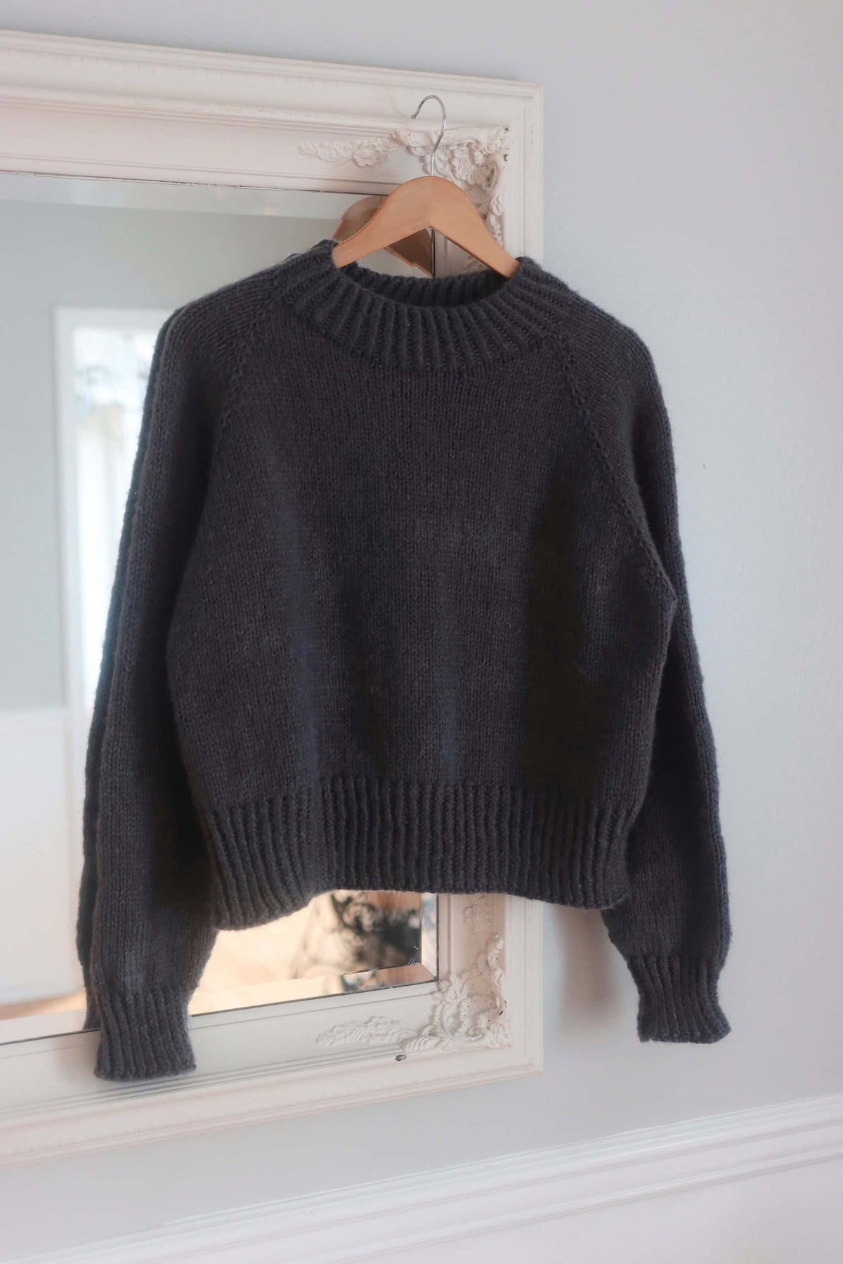 Close-up detail of The Ash Sweater knitting pattern showing raglan construction and texture