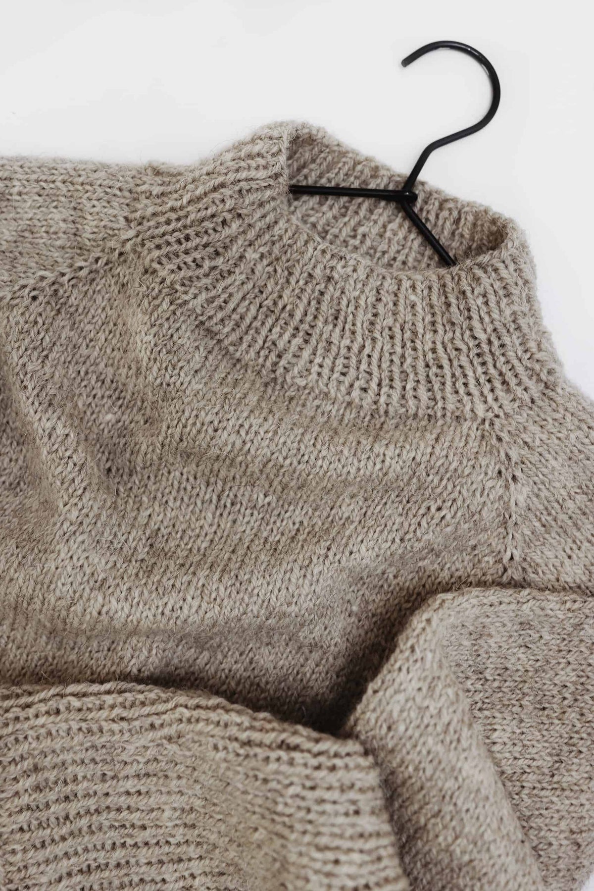 Cream knitted raglan sweater with ribbed cuffs laid flat showing seamless construction - Comfort Sweater by Darling Jadore