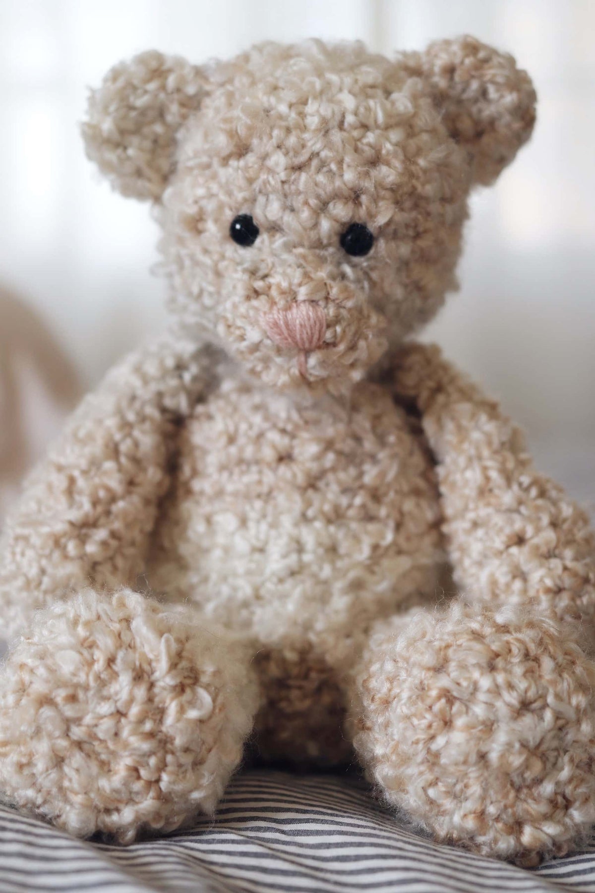 Handcrafted amigurumi teddy bear crochet toy in neutral tones for baby or nursery decor