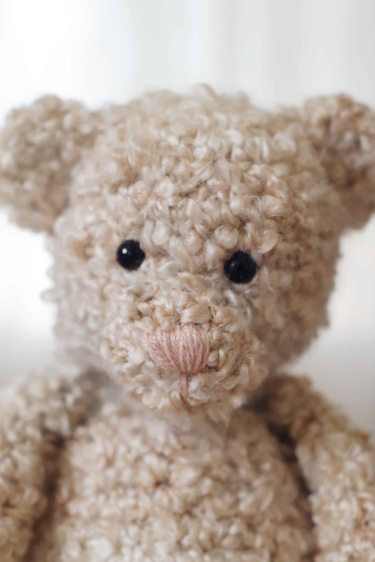 Close-up of classic amigurumi teddy bear crochet pattern showing stitch detail and texture