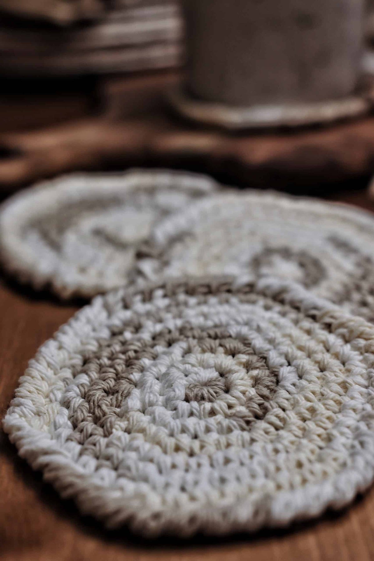 Stack of handmade round crochet coasters with rope edging - DIY home decor crochet pattern