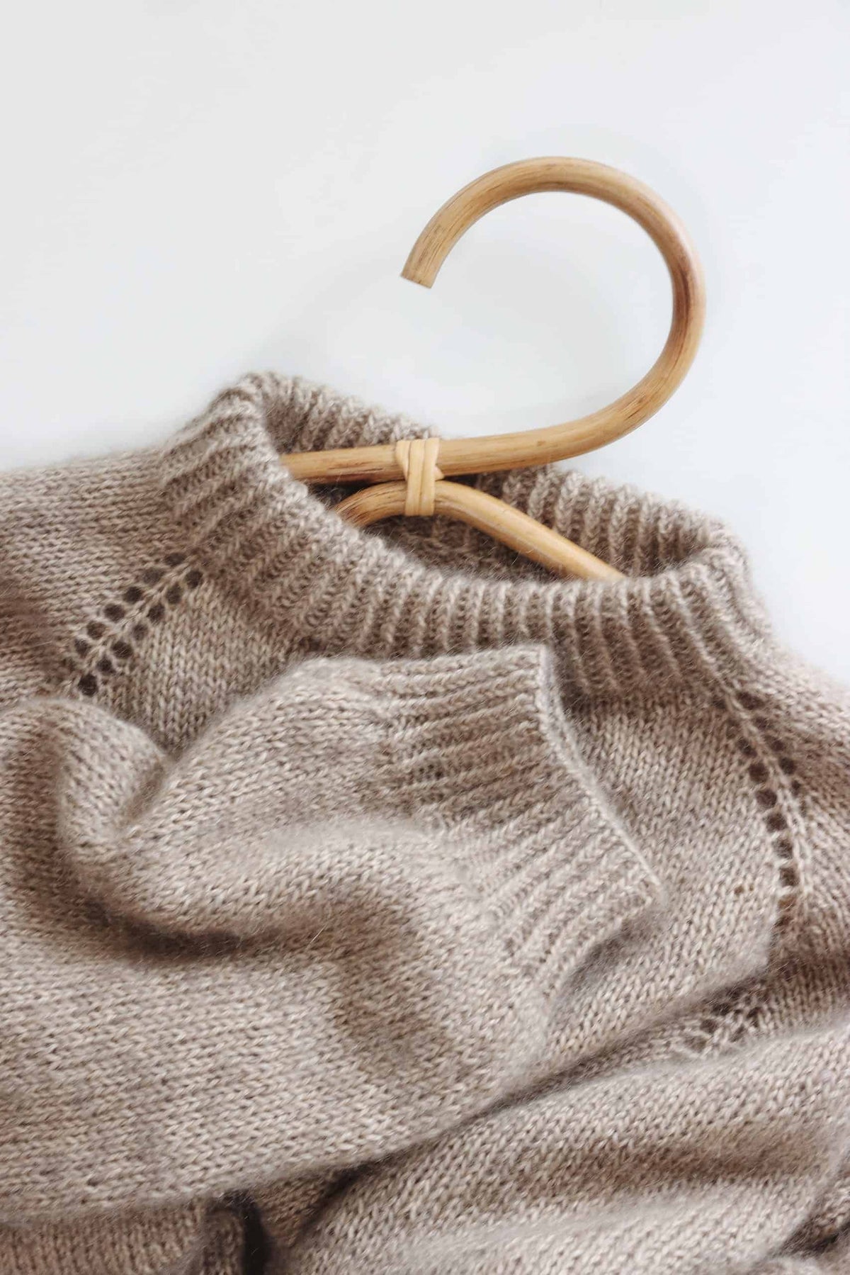 Woman in cream Café Sweater knitting pattern with timeless minimalist style