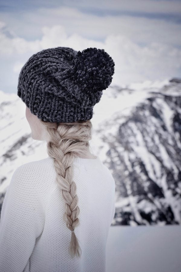Woman wearing cream chunky knit beanie with pom - easy winter hat knitting pattern by Darling Jadore