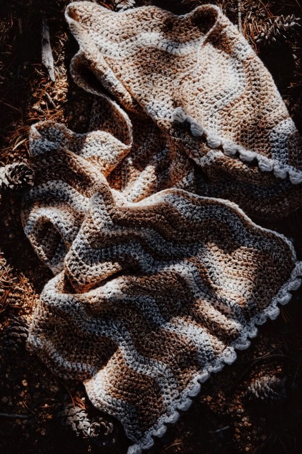 Knitted ribbed scarf in cream yarn draped elegantly - Riverbed Scarf knitting pattern by Darling Jadore