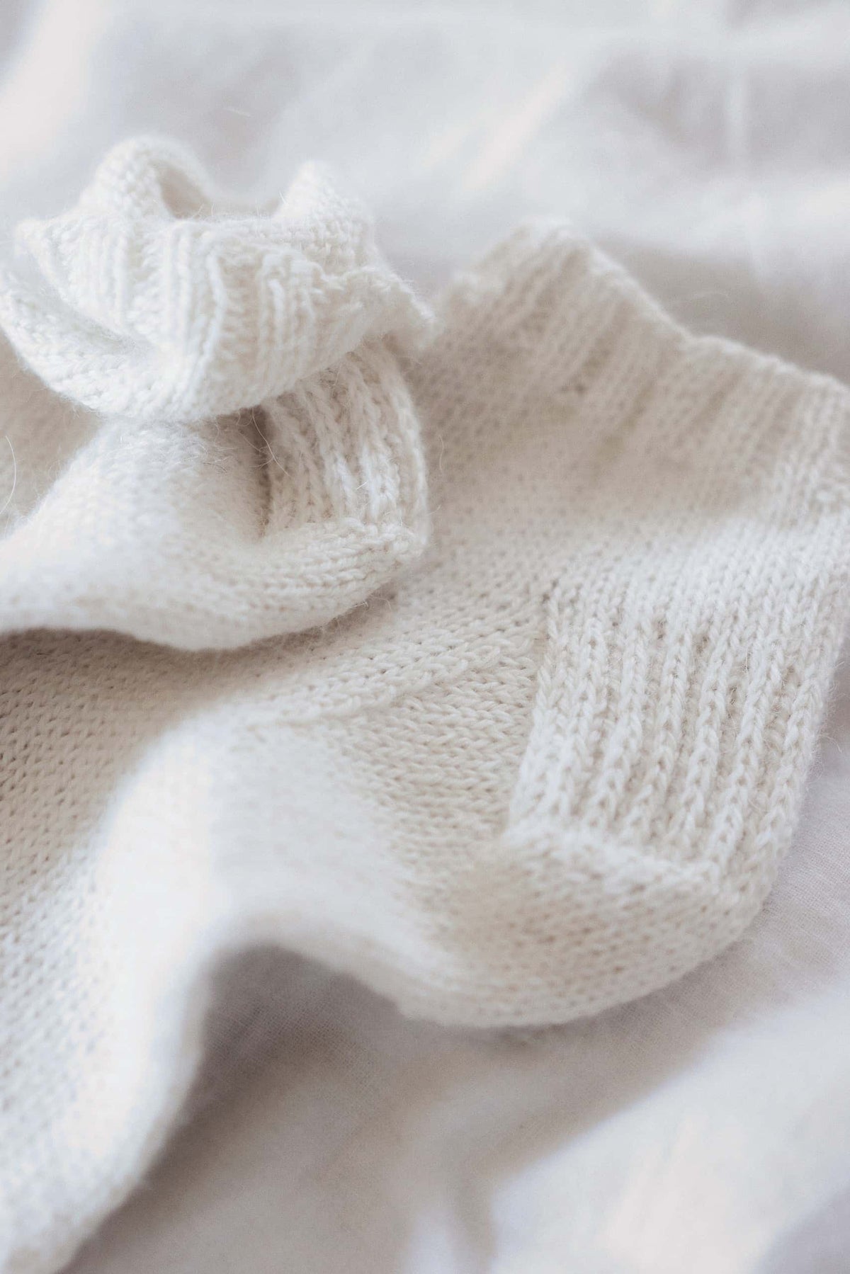 Classic ankle socks knitting pattern materials and finished cream socks flat lay
