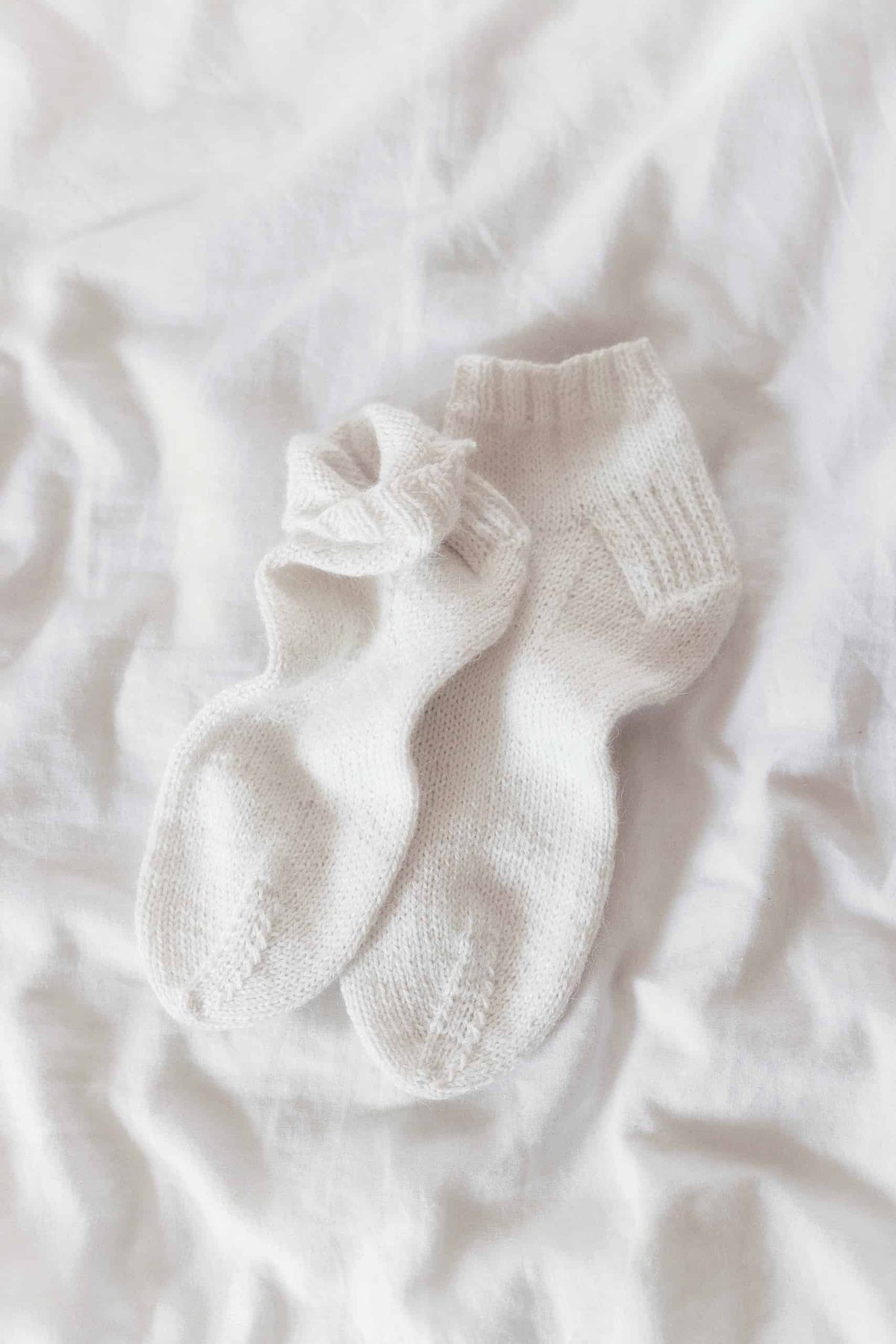 Hand knit classic ankle socks pattern in natural yarn with ribbed cuff detail