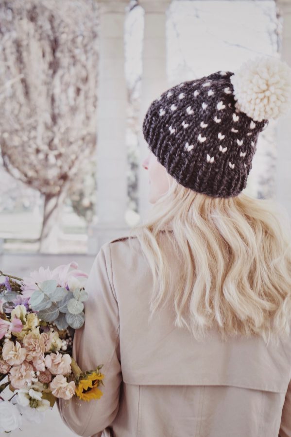 Woman wearing handknit fair isle beanie with pom pom in winter setting