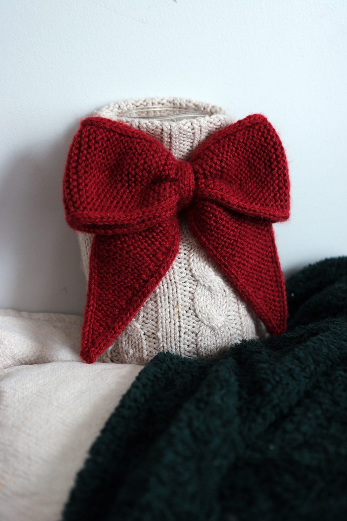 Handknit bow ornament in cream yarn with timeless appeal
