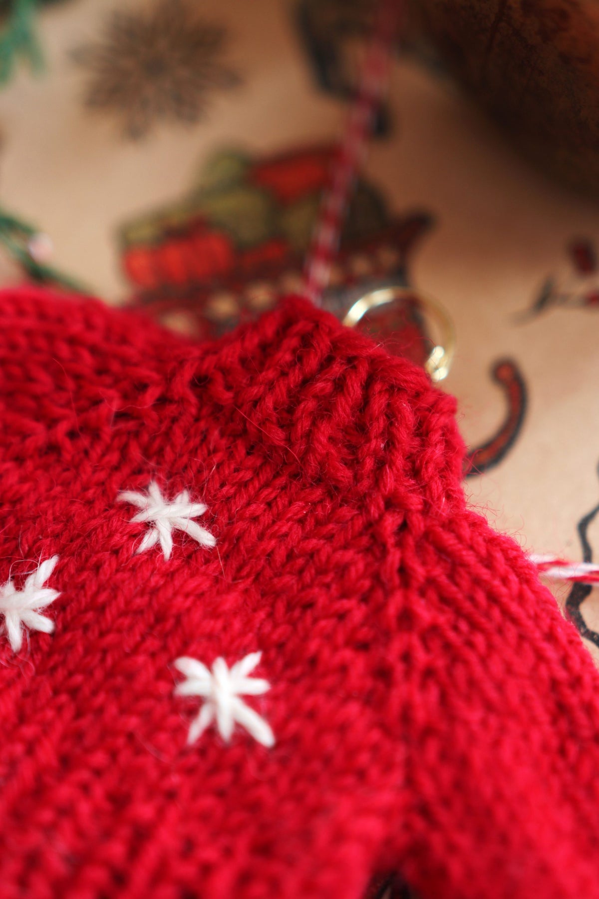 Beginner-friendly knit sweater ornament pattern displayed with festive holiday decorations