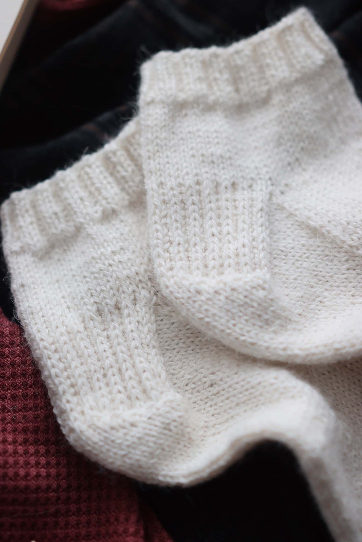 Beginner friendly ankle socks knit pattern in cream yarn lifestyle photo