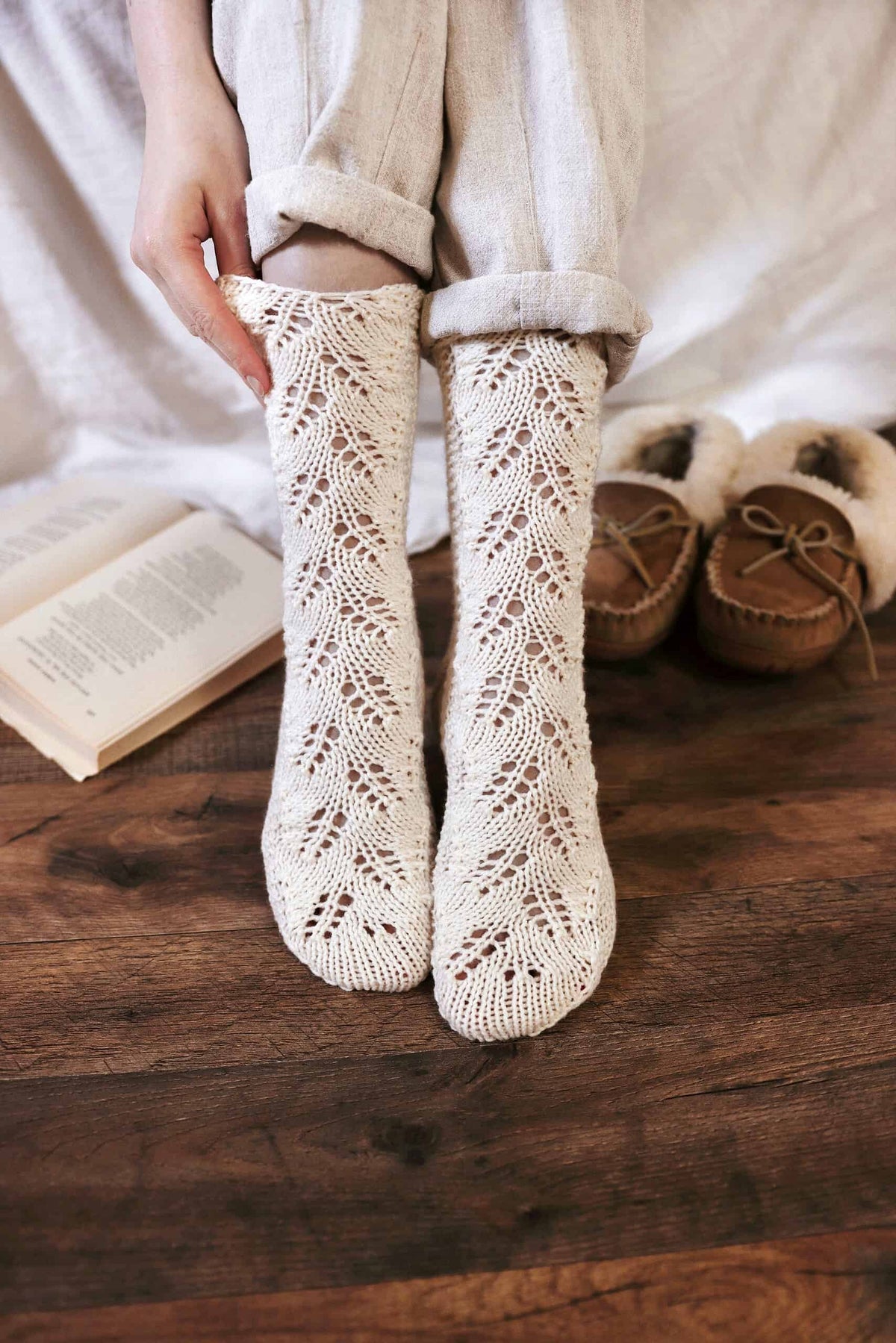 Lace knit socks in cream yarn showing delicate eyelet pattern detail - Juniper Socks knitting pattern by Darling Jadore