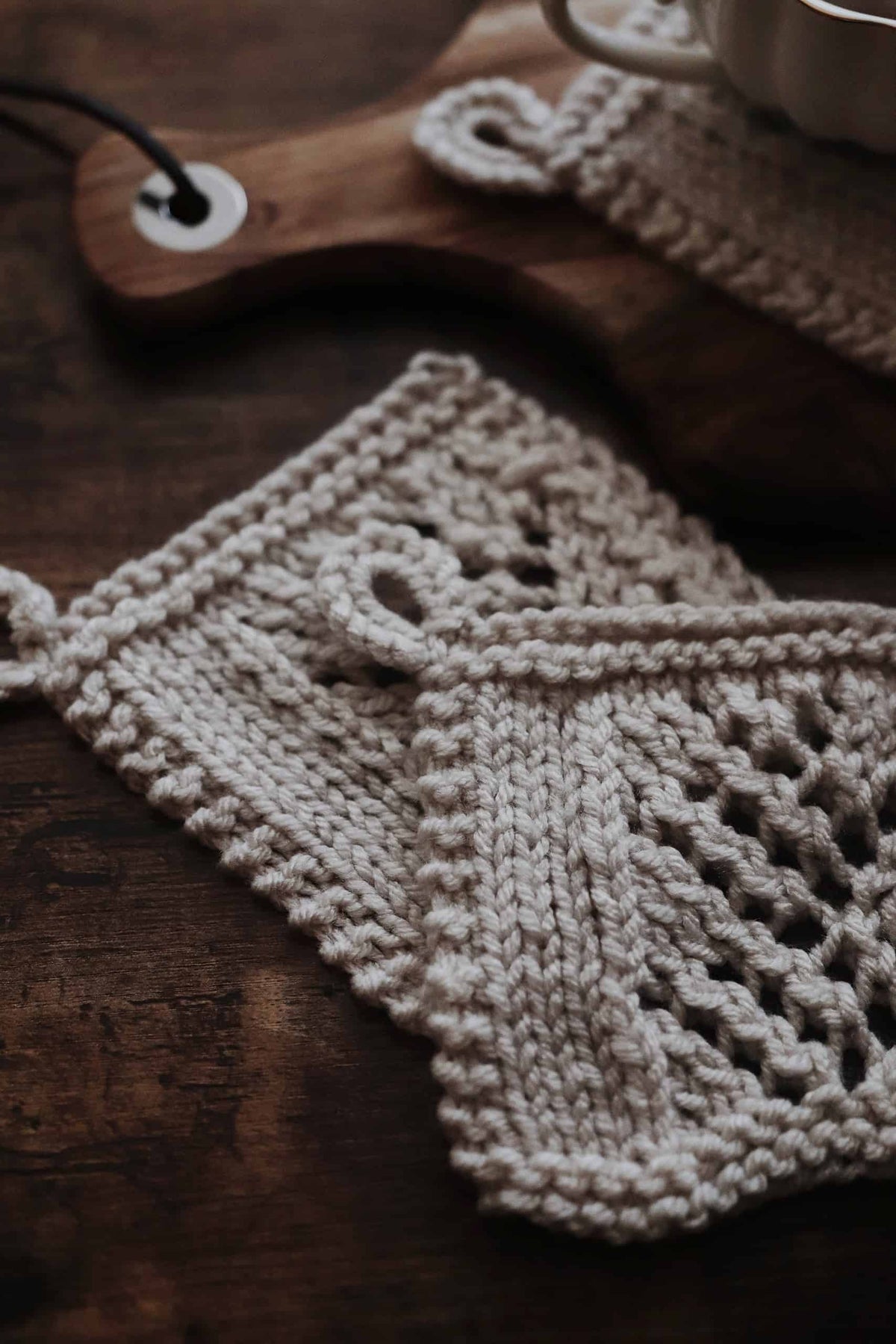 Close-up of Wheatfield coaster showing delicate lace knitting pattern and structured edging detail