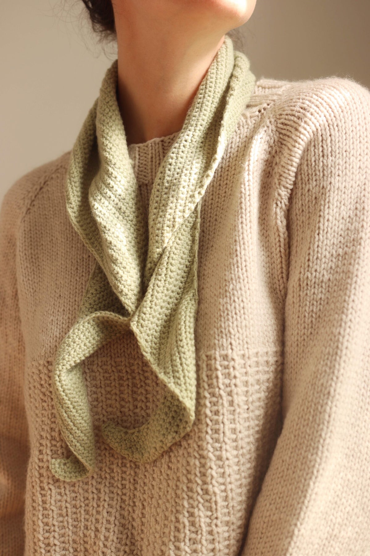 Sage green crochet skinny scarf over a cream sweater - The Saturday Scarf Crochet Pattern by Darling Jadore