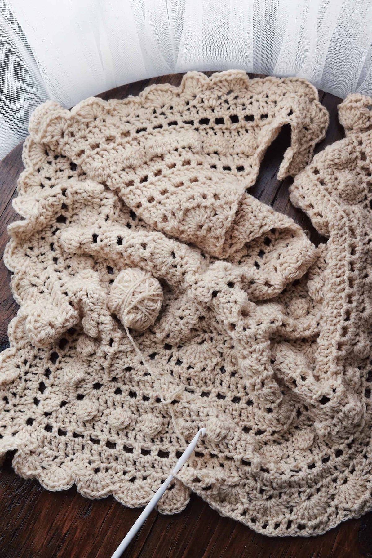 Close-up texture of ivory lace triangle scarf showing bobble details and vintage crochet lacework