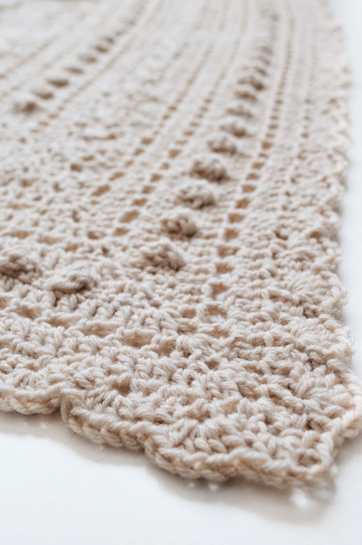 Woman modeling ivory lace triangle shawl with vintage bobble pattern - Isla Scarf crochet design