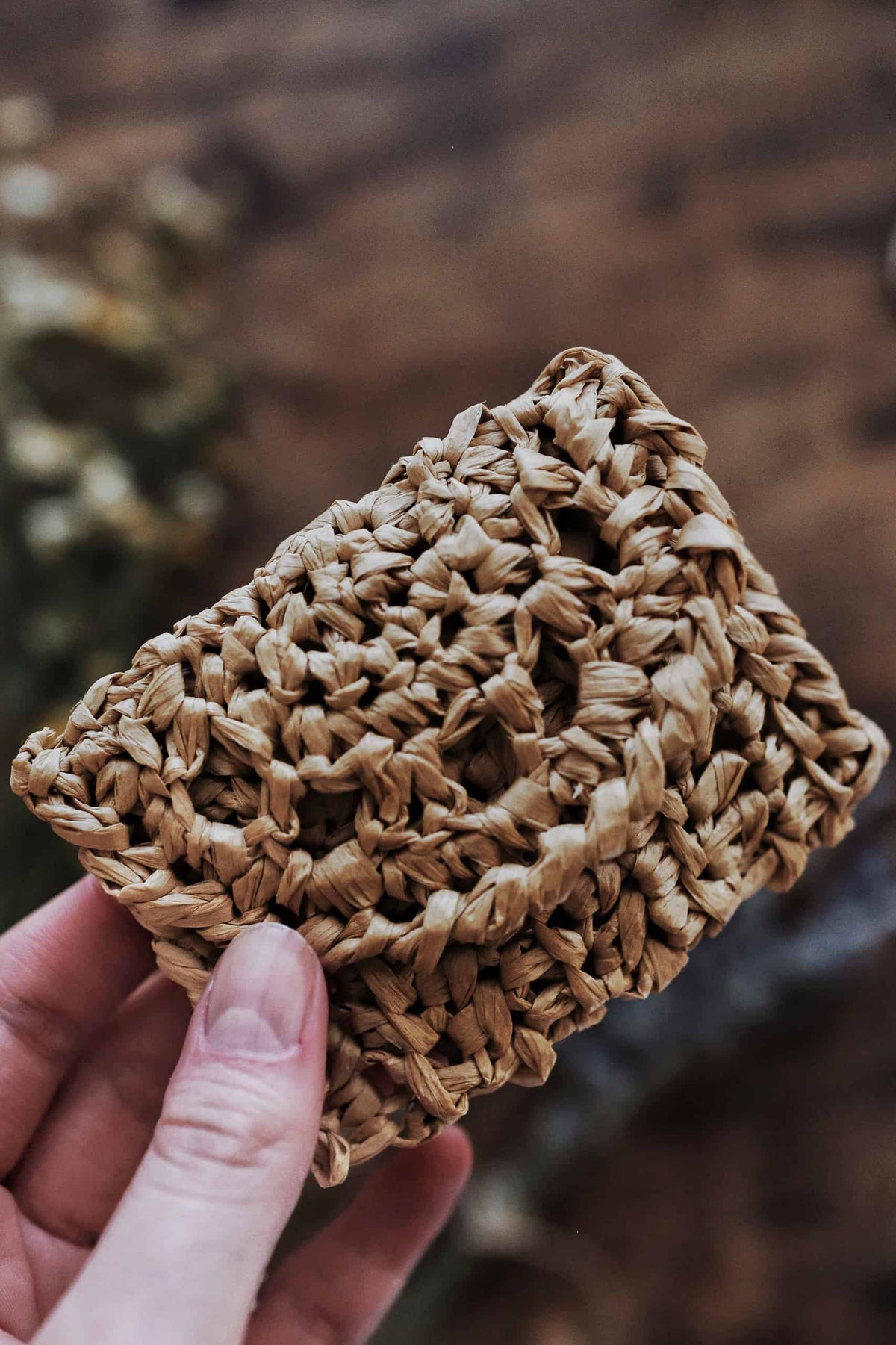 Natural raffia crochet coin purse displayed flat showing eyelet lace pattern detail