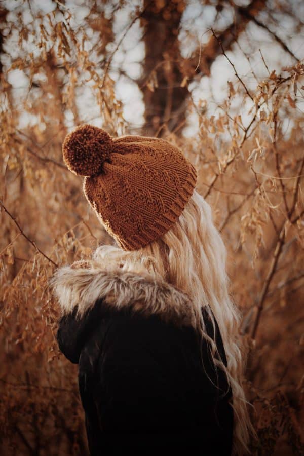 Woman modeling cream Prairie Beanie hat with elegant faux cable knit design